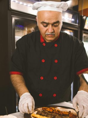 Middle Eastern chef preparing a traditional shawarma dish at a restaurant in Louisville.